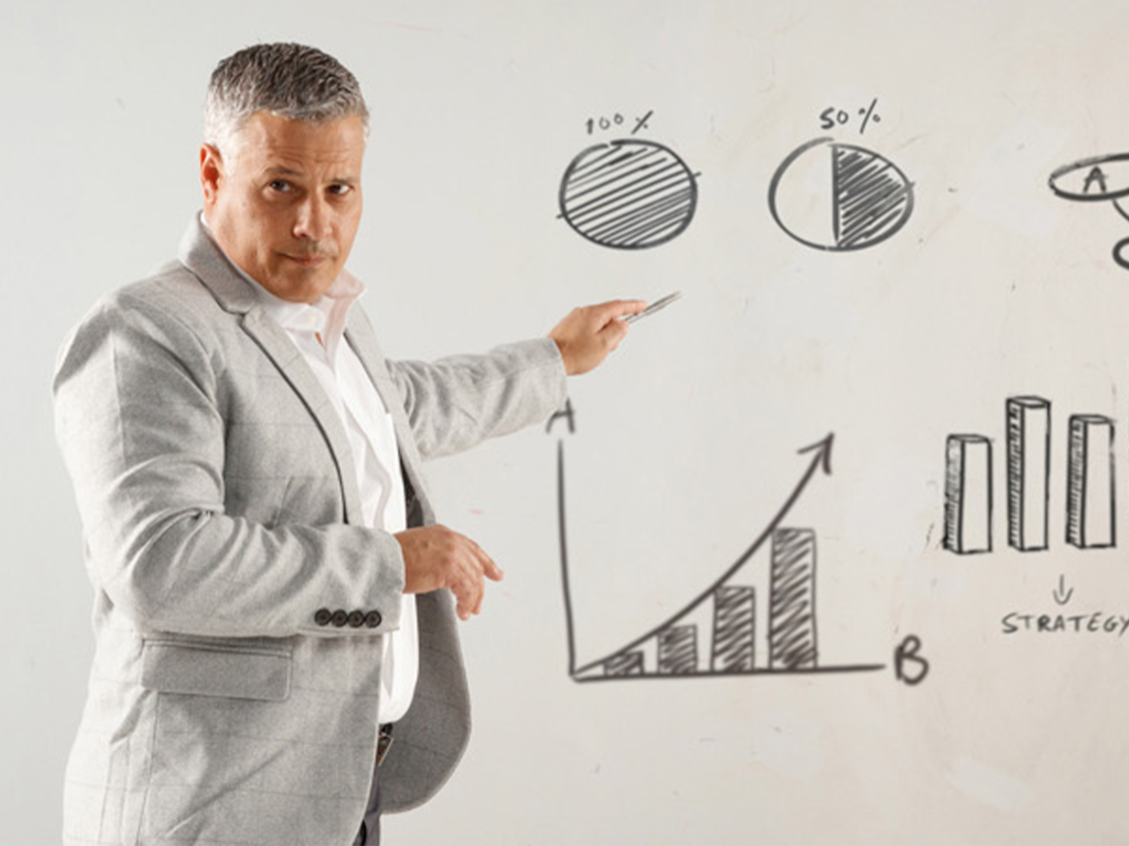 man pointing to graphs on a whiteboard